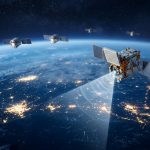 Costellazione di satelliti LEO sopra la Terra di notte con un fascio di segnale verso il suolo, immagine su Elveo Mobile nata dalla fusione Lynk-Omnispace