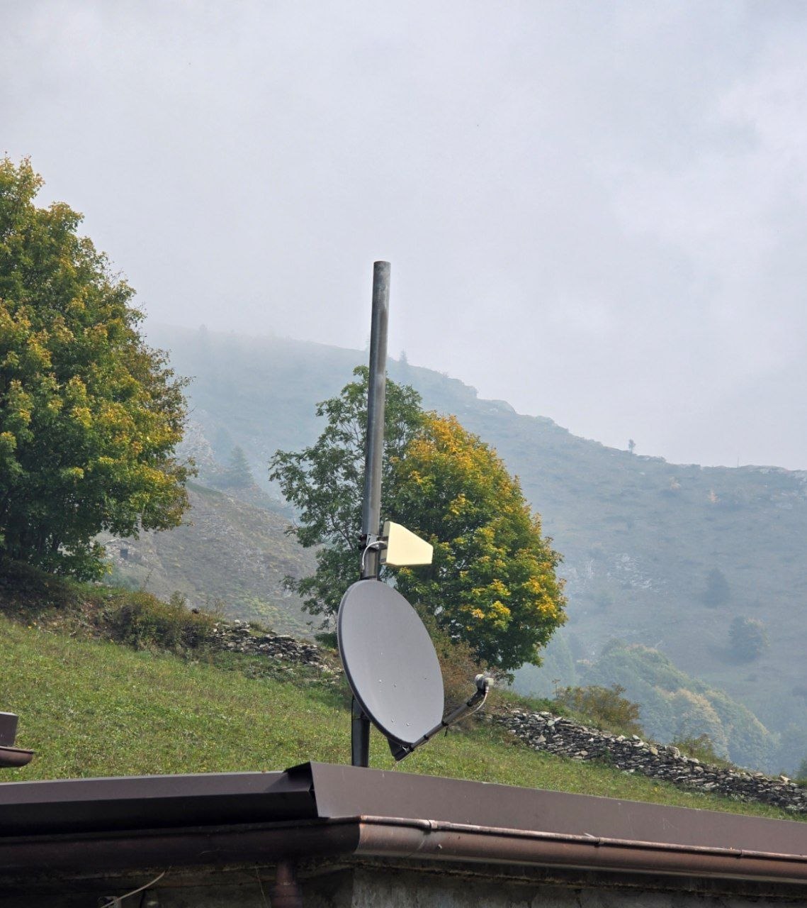Palo su una casa di Bellino con una parabola e una piccola antenna direttiva per il ripetitore del segnale mobile