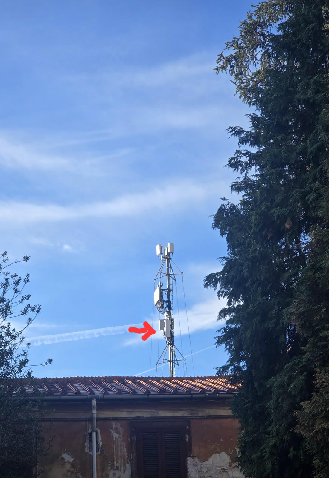 Il carrato Vodafone di Lucca Comics 2026 spunta sopra un tetto di tegole; una freccia rossa indica un pannello aggiuntivo sul palo