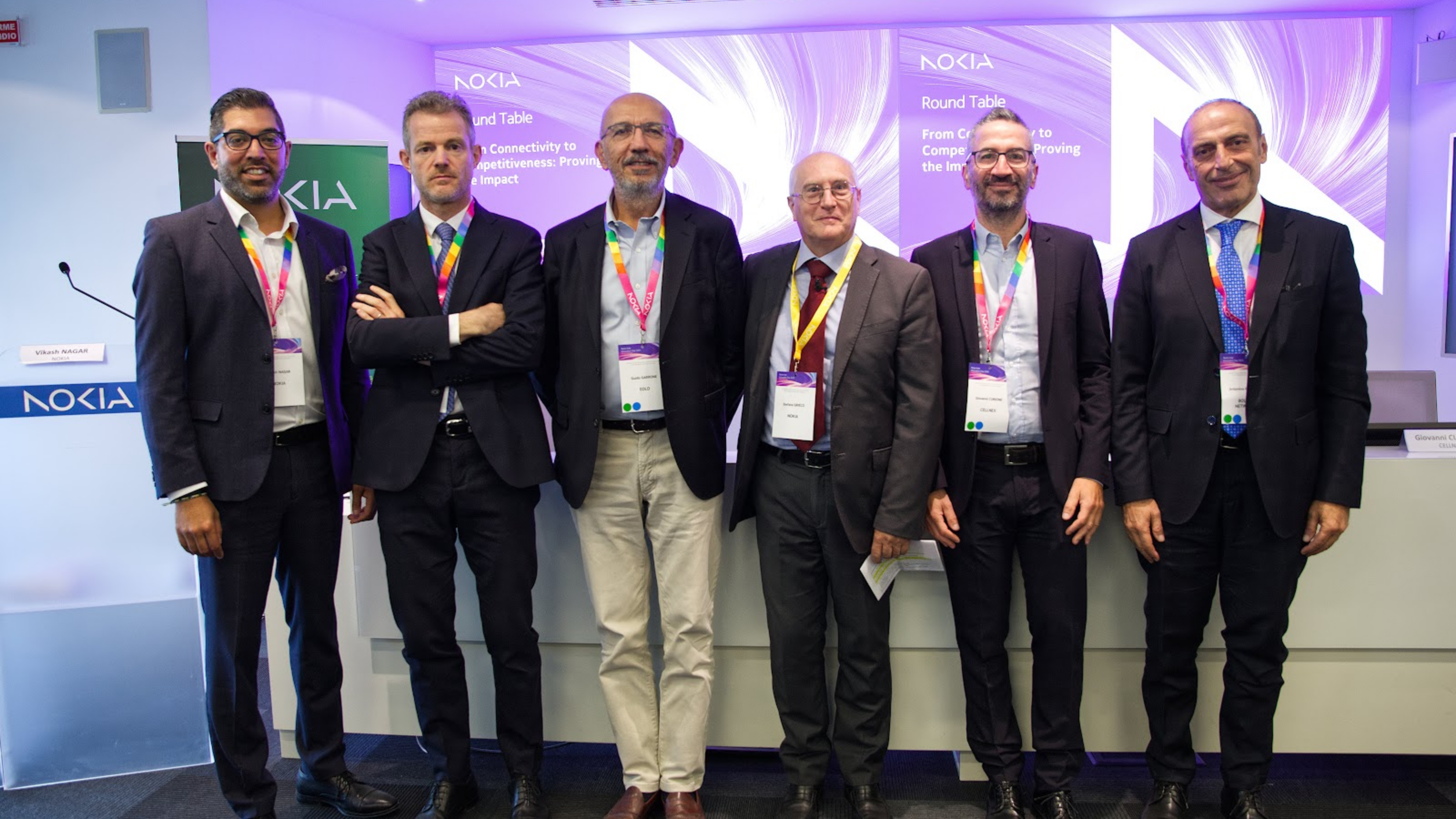 Foto di gruppo della tavola rotonda From Connectivity to Competitiveness al Nokia Italy Innovation Day 2026 di Vimercate, davanti al logo Nokia